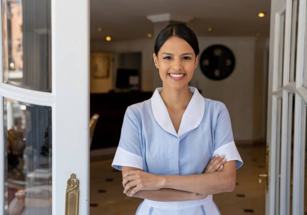 Friendly Latin American Maid Working At A Hotel And Standing At The Friendly Latin American Maid Working At A Hotel And Standing At The